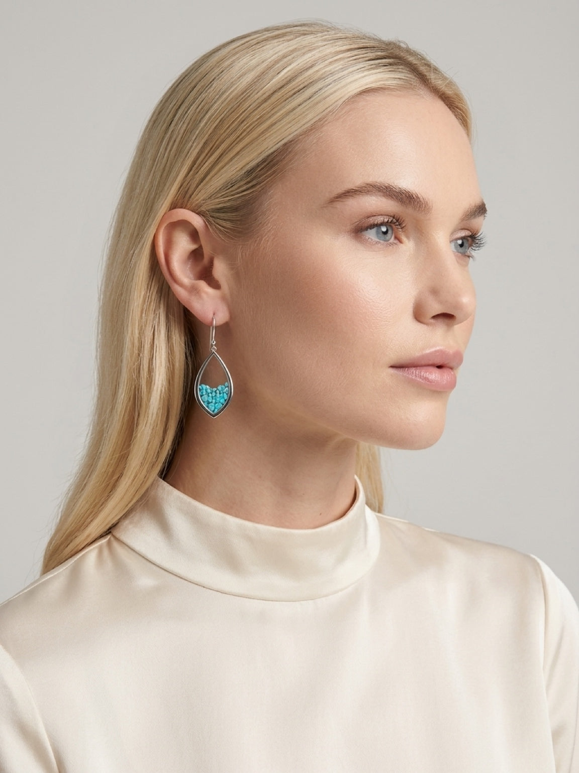 Gold finish turquoise chip teardrop earrings worn on model